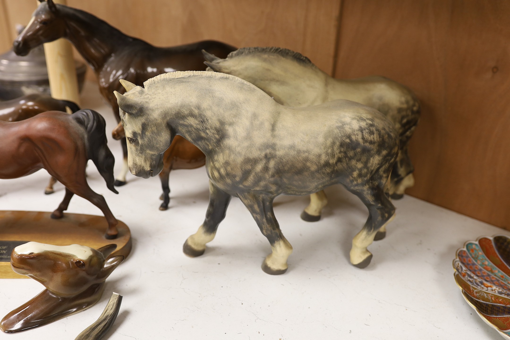 A collection three single Beswick horses, a group figure of a mother and foal, a wall pocket and two Lenham pottery shire horses, tallest 28 cm